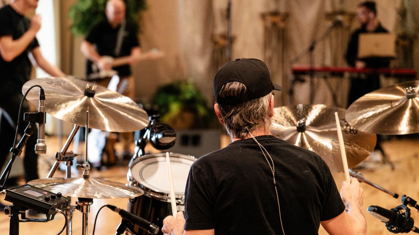 Drummer and band during a live recording session engineered by Emerald Wave