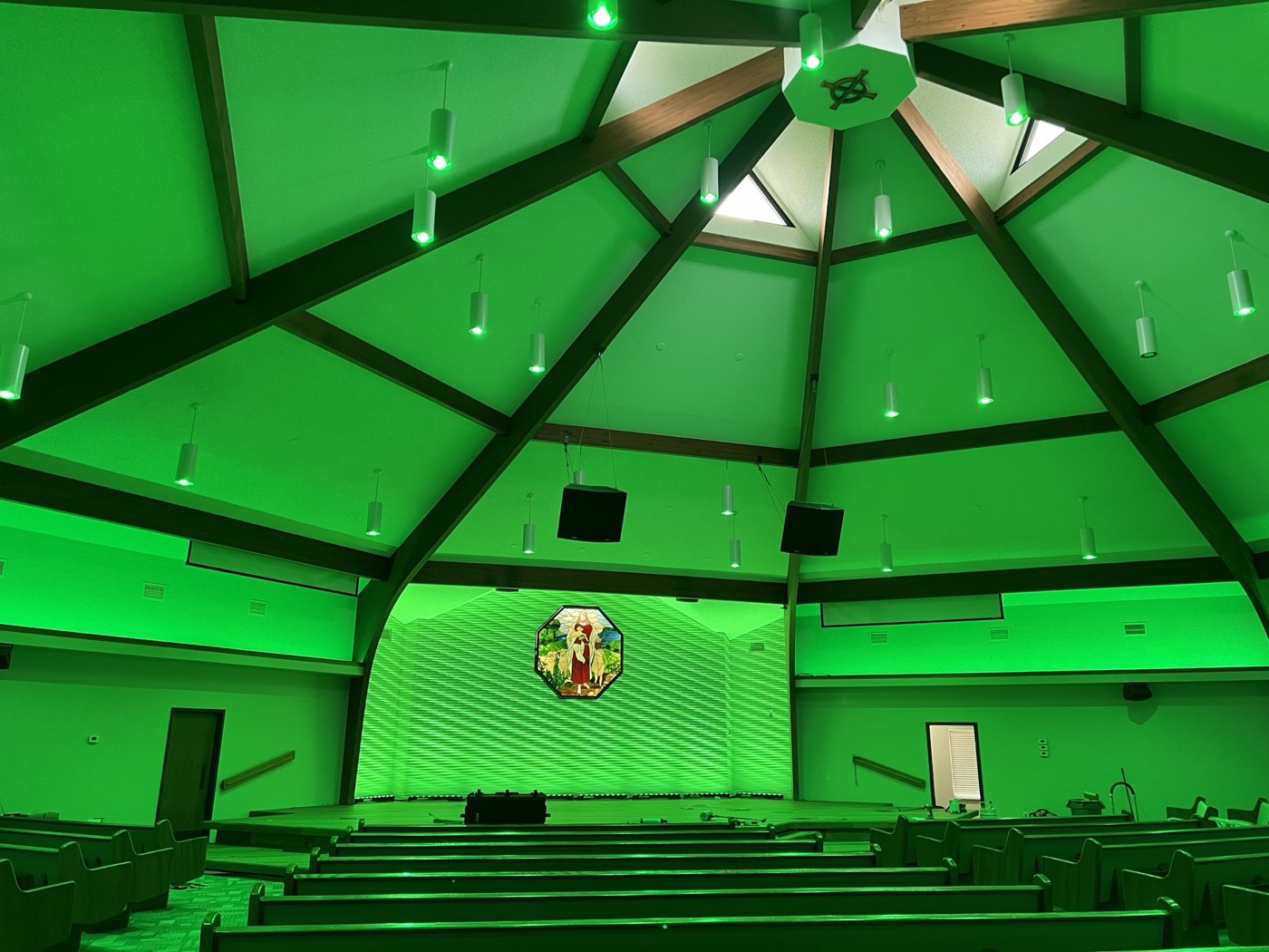 Vaulted sanctuary washed in emerald green light at Crossroads Church, Mustang